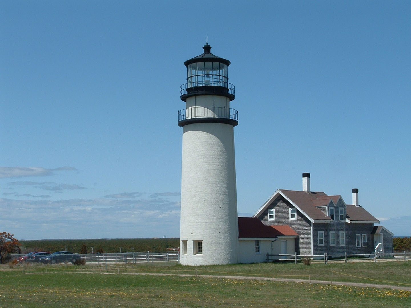 Highland Light’s white tower and keeper’s house under a blue sky