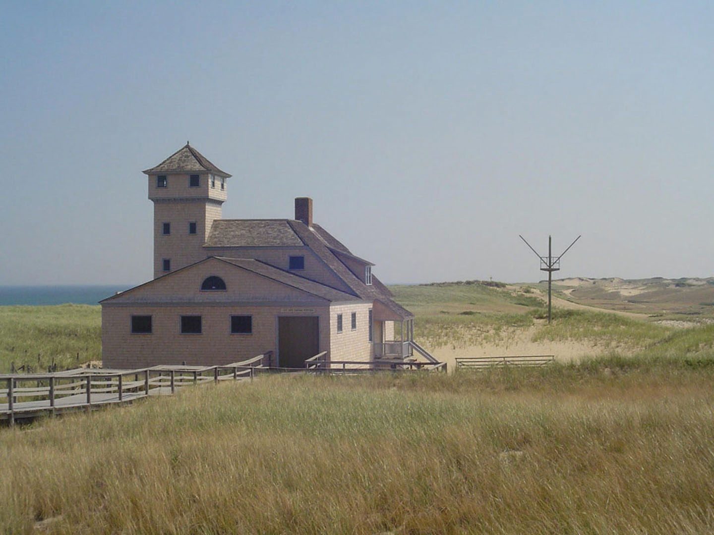 The shingled Old Harbor Life-Saving Station in the dunes on a clear day