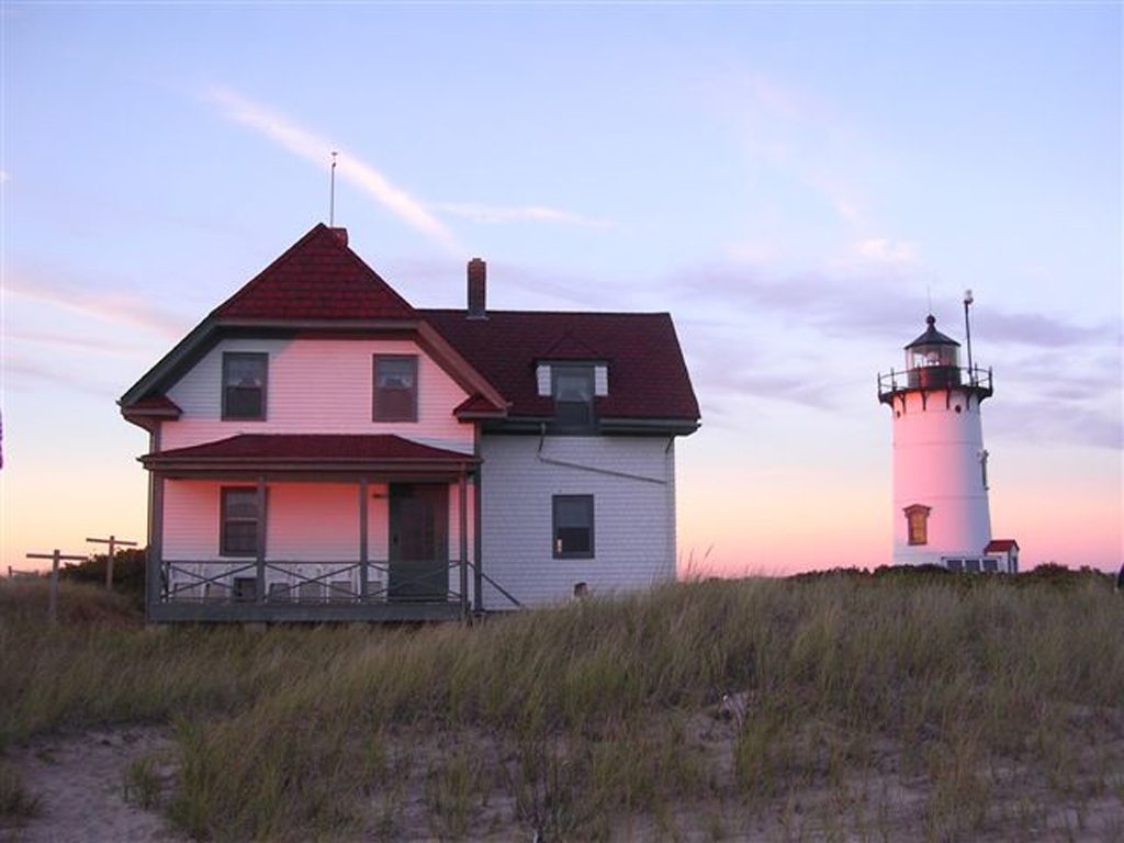 The keeper’s house and Race Point Light glowing pink at sunset