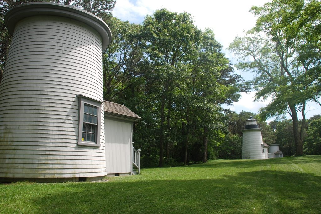 The Three Sisters lighthouses on a green lawn among trees